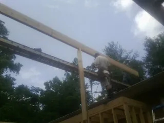 Carpenter setting a ridge beam over a new addition frame — Ice Dam Removal by Roofing Brothers in Mumford
