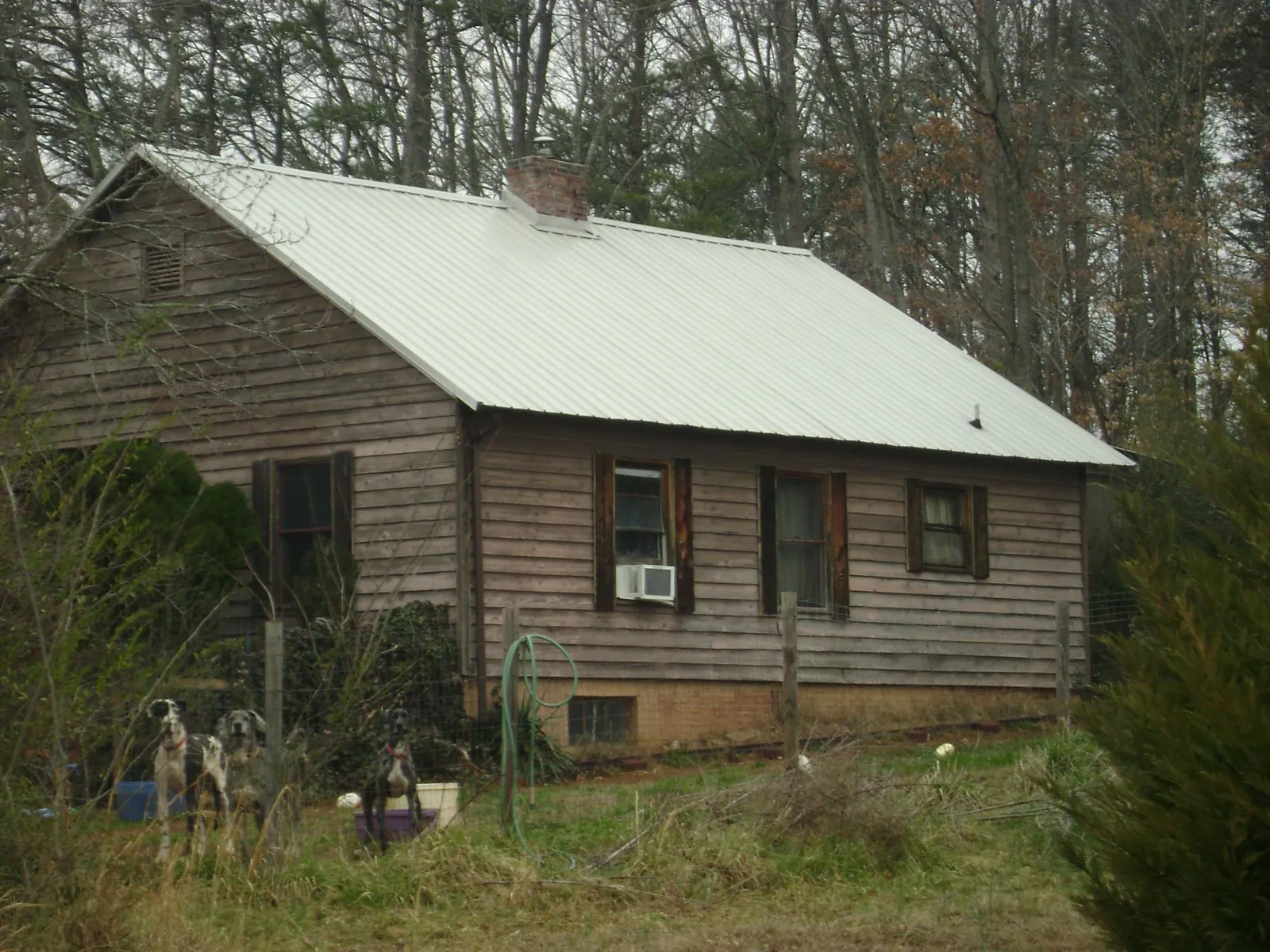 White metal roof on an old wood sided farmhouse, from a Metal Roof Installation job in Mumford